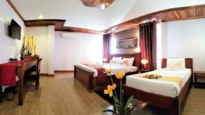 A hotel room with two beds, a desk, a TV, and a large window with curtains. - Wheel Garden Riverside (Siem Reap)