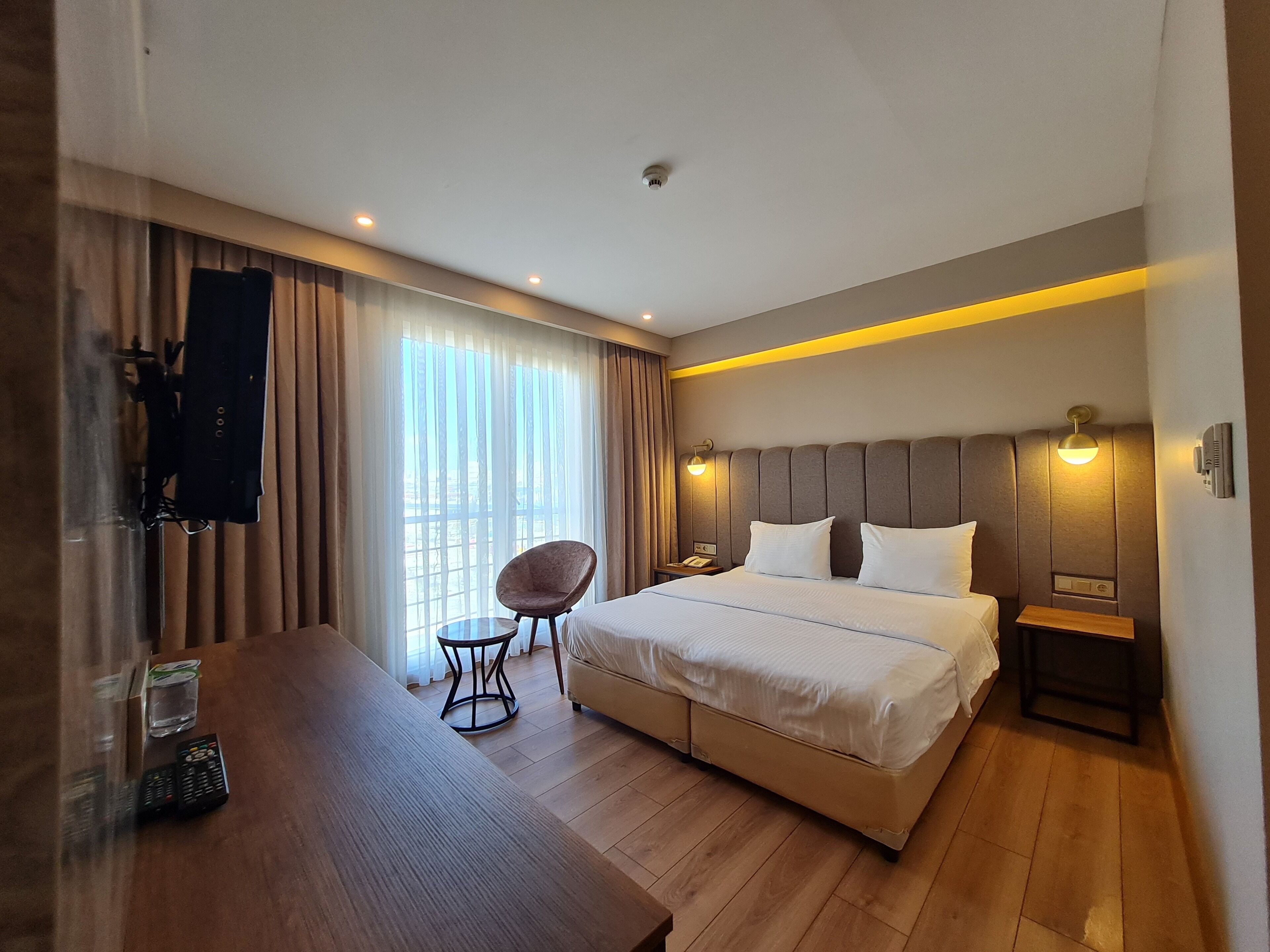 Una habitación de hotel con una cama, una silla, una mesa y un televisor.