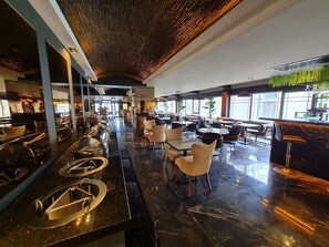 Un restaurant moderne doté d’un long comptoir, de plusieurs espaces de restauration et d’un bar.