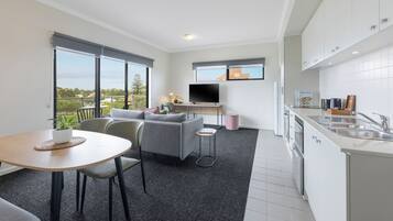 Um apartamento moderno com sala de estar, cozinha e varanda.
