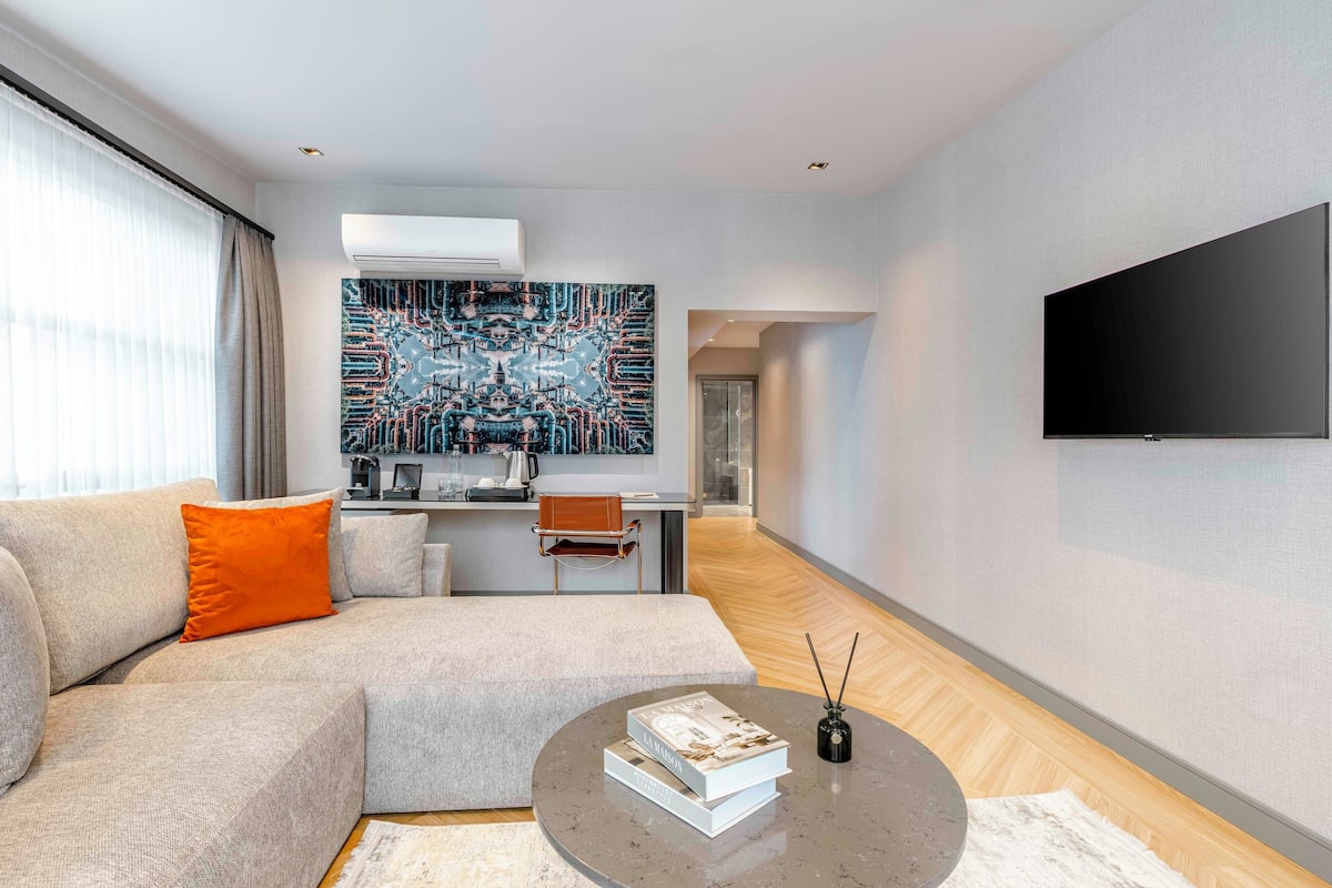 Uma sala de estar moderna com um sofá, mesa de centro e televisão de tela plana.