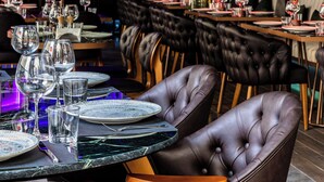 A restaurant with leather chairs, a marble table, and tropical plants. - AHC Taksim Hotel (Istanbul)