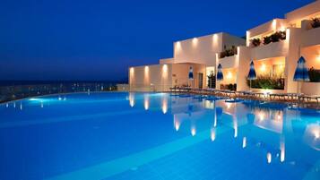 Een buitenzwembad, parasols voor strand/zwembad