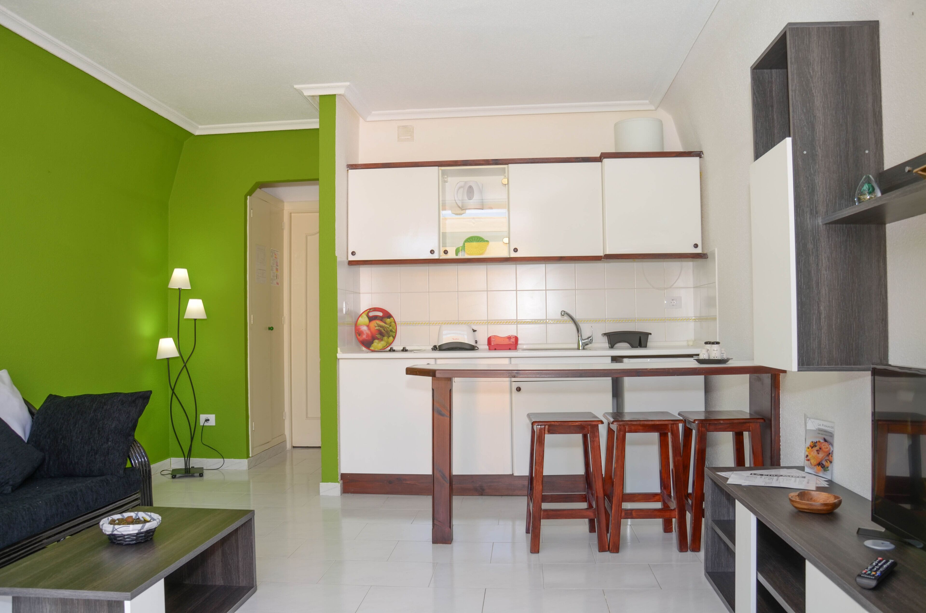 A compact living space with a kitchenette, a dining area, and a seating area.