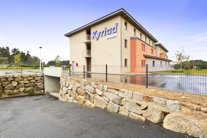 A hotel building with a sign reading "Kyriad Hotel". - Kyriad Saint Chely d'Apcher - Aire de la Lozère (Albaret-Sainte-Marie)