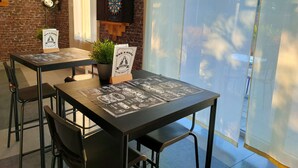 A restaurant with brick walls, a dartboard, and a menu stand. - Kyriad Saint Chely d'Apcher - Aire de la Lozère (Albaret-Sainte-Marie)