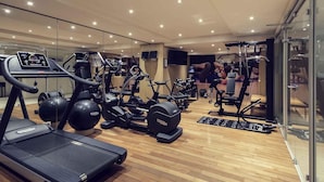 Ein modernes Fitnessstudio mit Laufbändern, Crosstrainern und Gewichtsmaschinen.