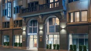 Ein Hotel mit einer modernen Fassade, großen Fenstern und einem markanten Eingang.