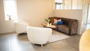 A modern living room with a sofa, two armchairs, a coffee table, and a rug. - HotelVFjorden (Lemvig)