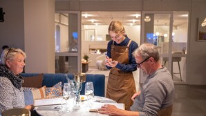 A dining area with a table set for four, including wine glasses and a menu. - HotelVFjorden (Lemvig)