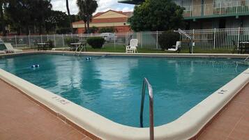 Una piscina al aire libre, sombrillas, tumbonas