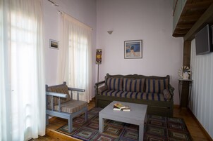 Ett mysigt vardagsrum med en soffa, en fåtölj, ett soffbord och en mönstrad matta.