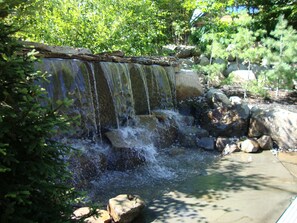 A small waterfall in a natural setting with rocks and greenery.