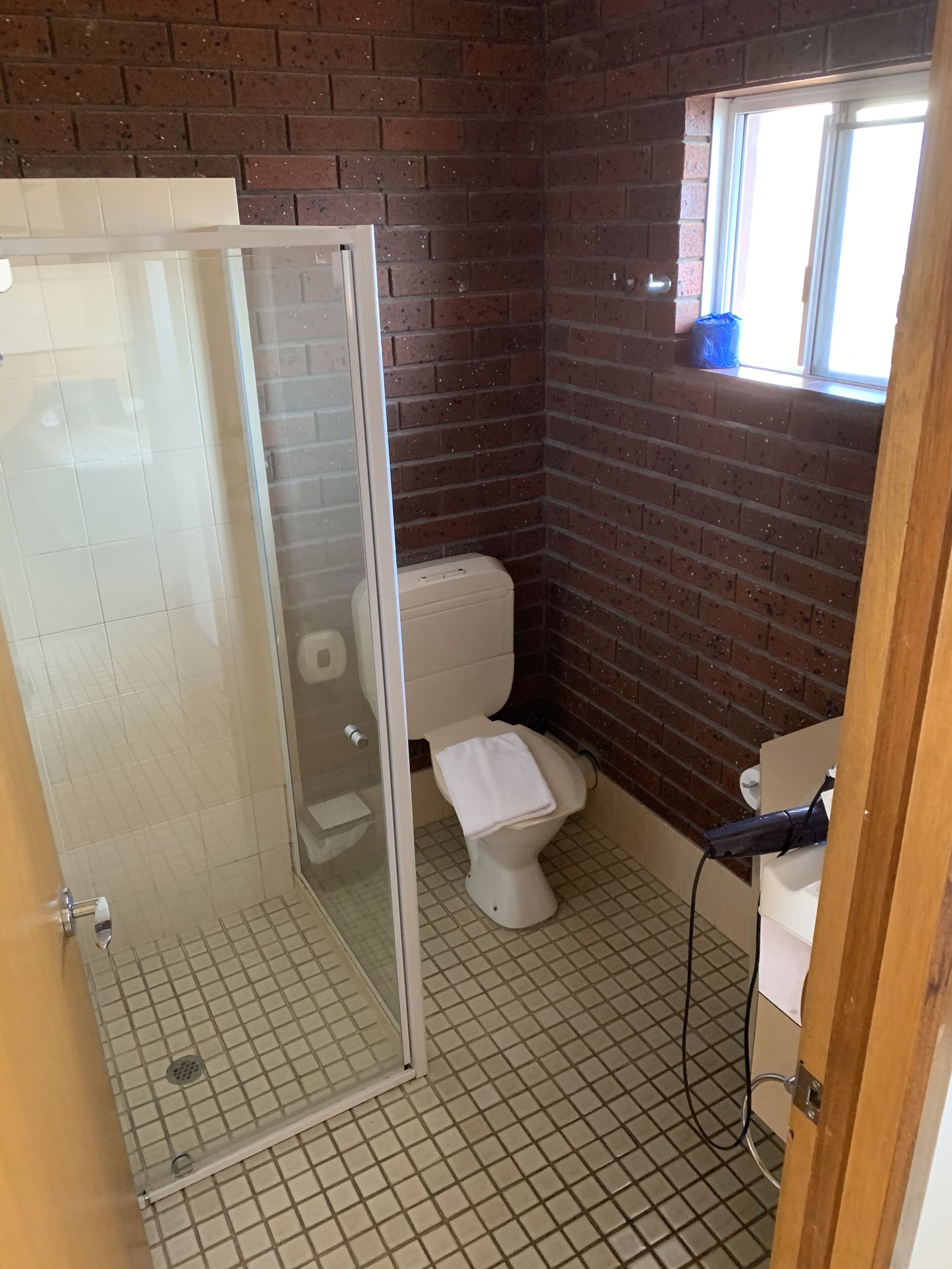 Een badkamer met een douchecabine, een toilet en een wastafel.