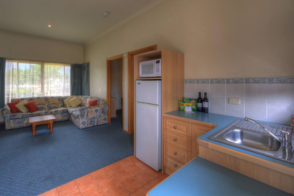 A compact living space with a kitchenette, a sofa, and a dining area.