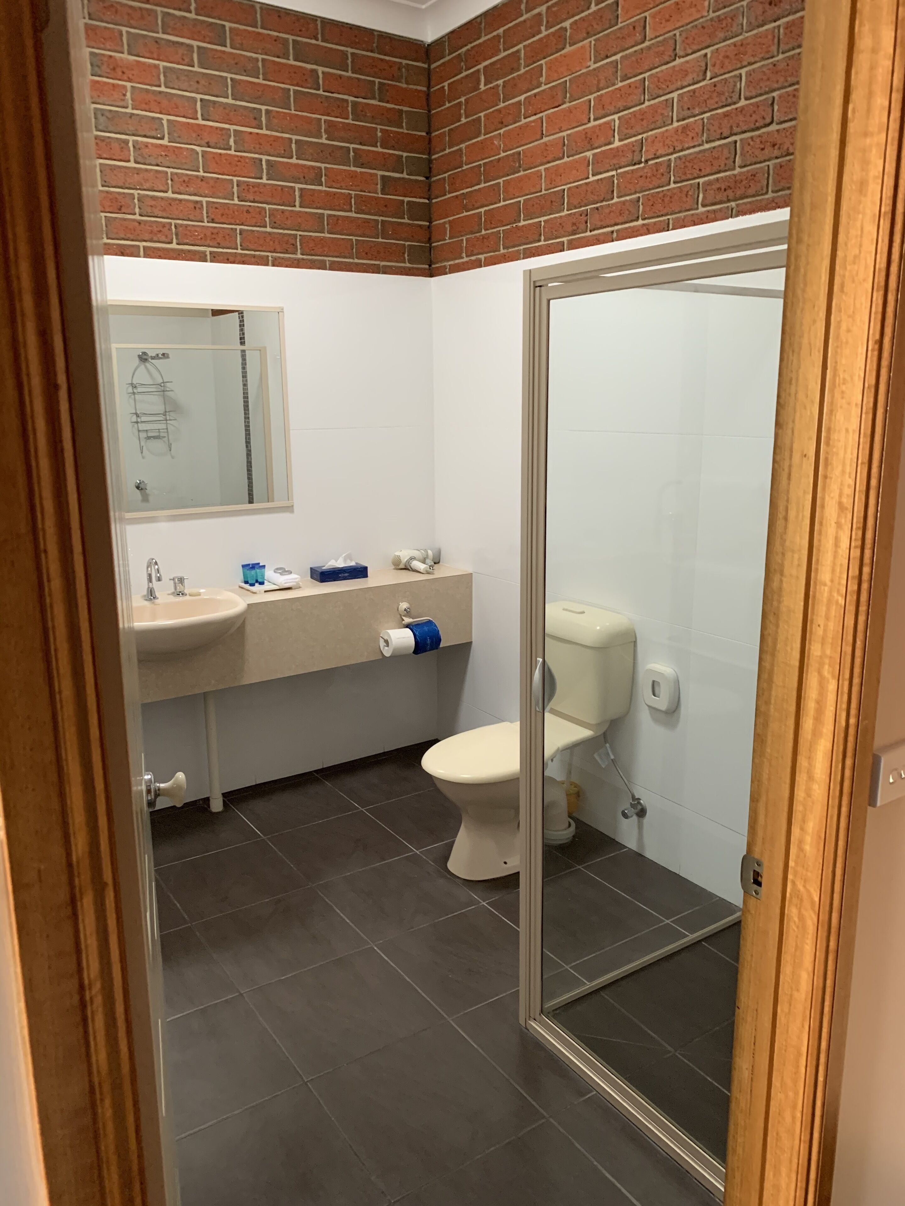 Un baño con lavamanos blanco, inodoro y espejo.