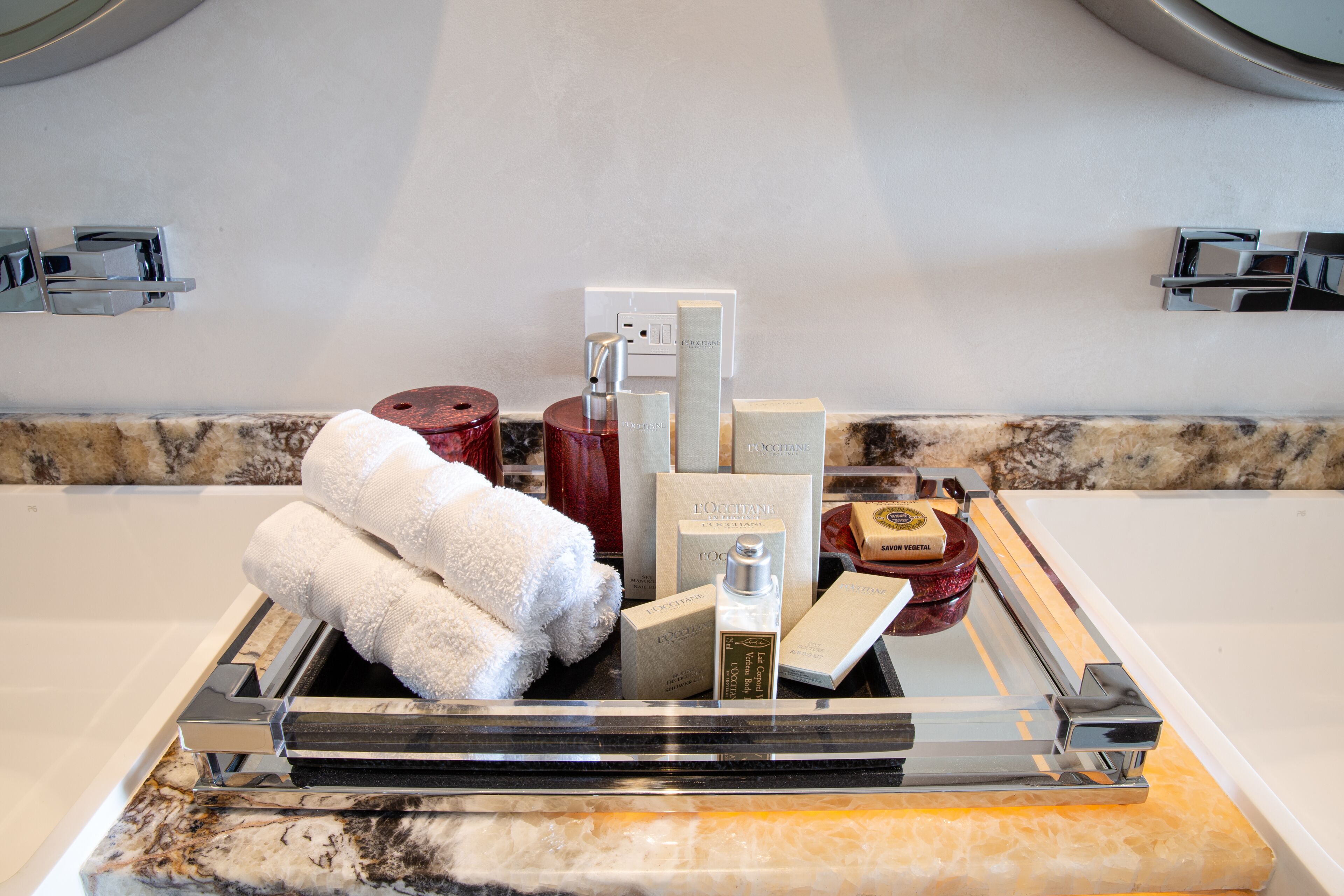 A bathroom vanity with a marble countertop, a towel rack, and various toiletries.