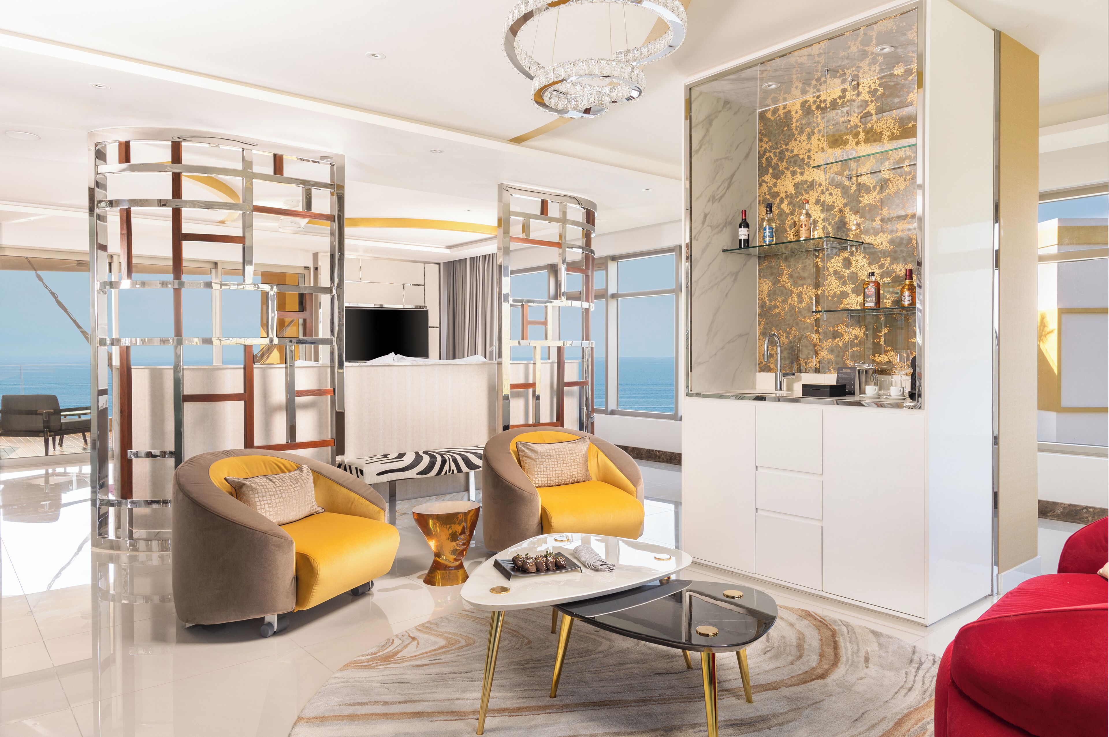 Een moderne woonkamer met een bank, fauteuils, een salontafel en een televisie.