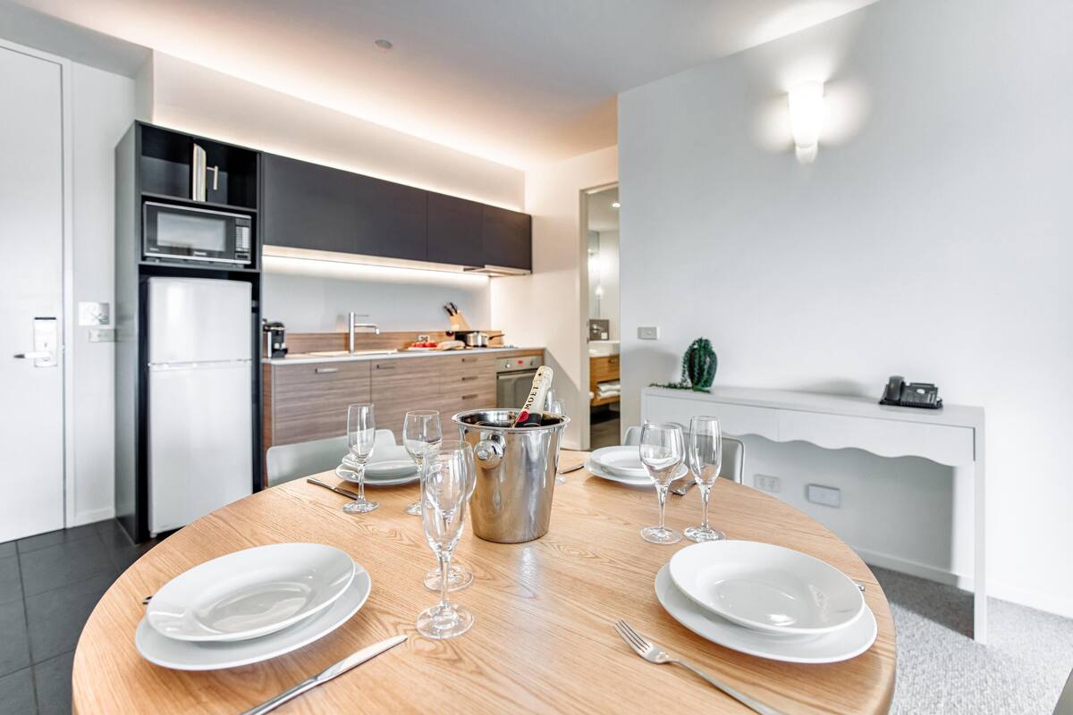 A modern kitchen with a dining area set for a meal.