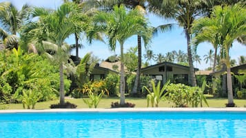 Una piscina al aire libre, sombrillas, sillones reclinables de piscina