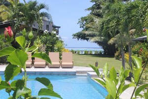 Una piscina al aire libre, sombrillas, tumbonas