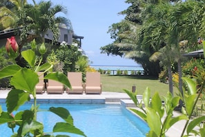 Een buitenzwembad, parasols bij het zwembad en ligstoelen