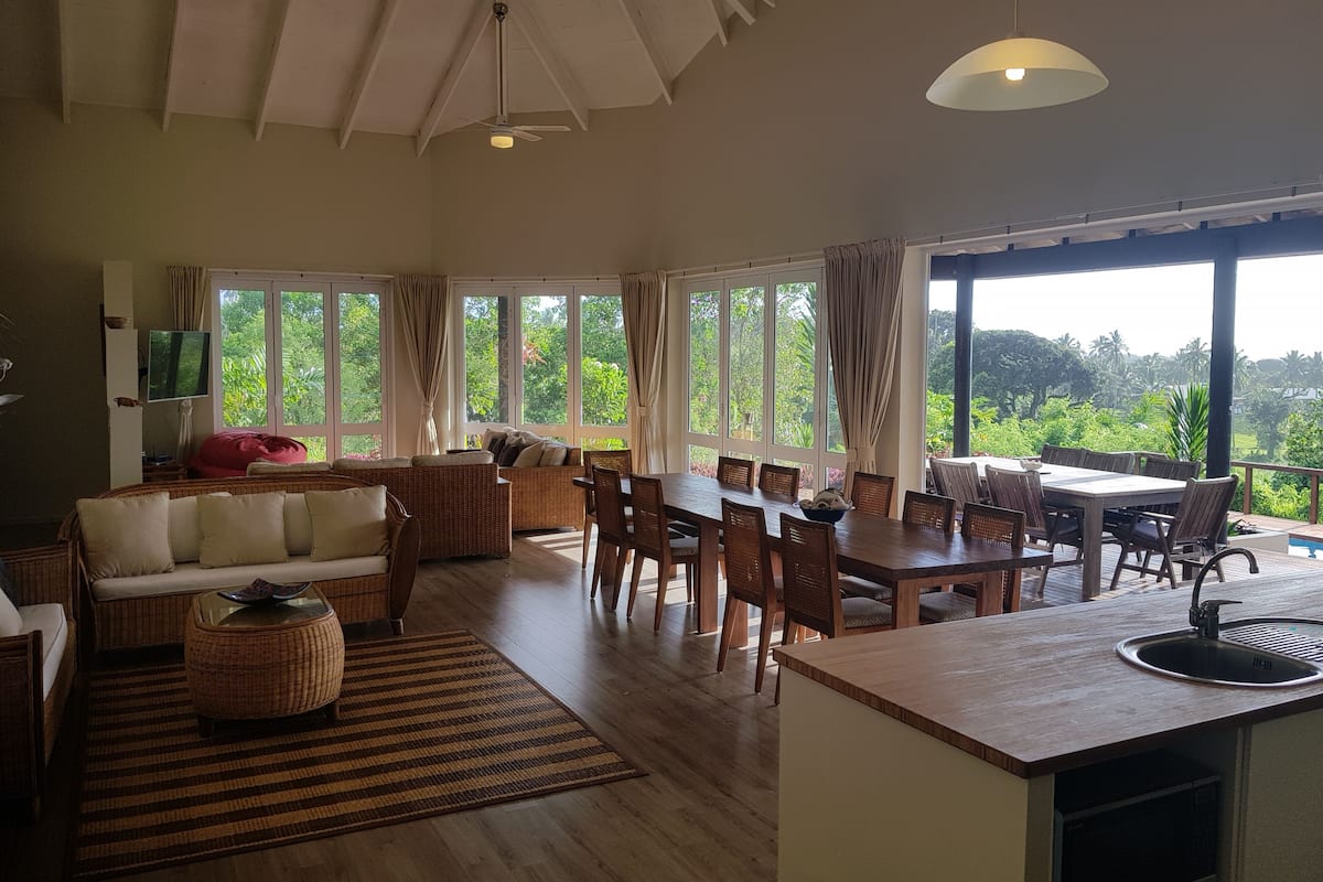 Una habitación amplia con comedor, sofá y televisor.