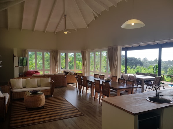 Una habitación amplia con comedor, sofá y televisor.