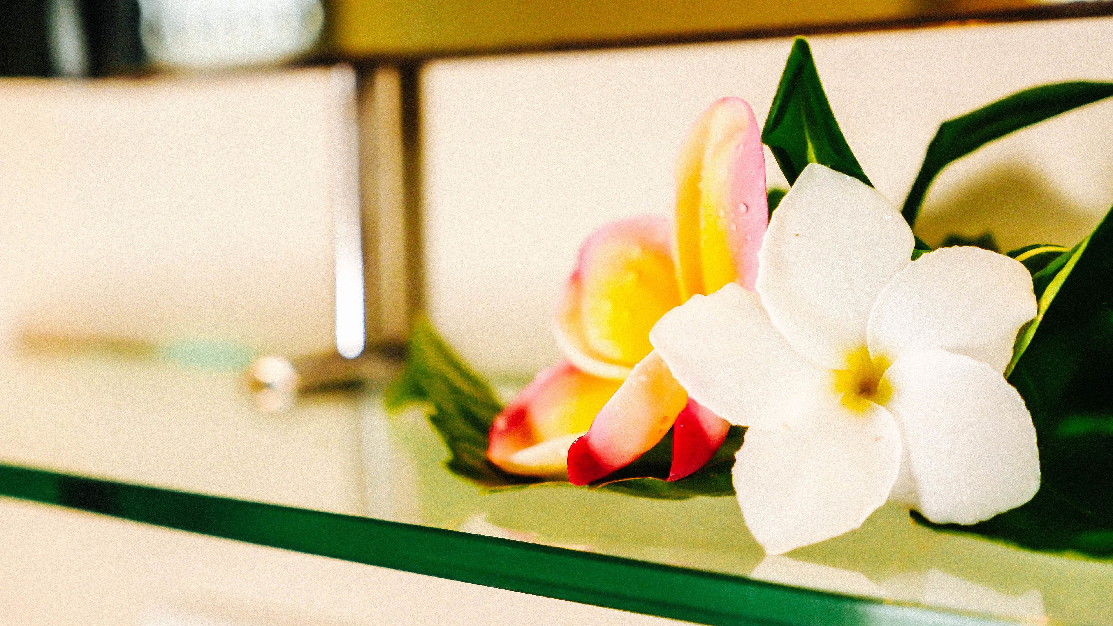 A glass table with a bouquet of flowers.