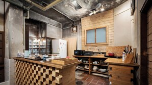 Une cuisine avec des meubles de rangement en bois, un réfrigérateur, un four à micro-ondes et un évier.