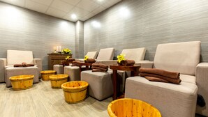 Een wellnessruimte met meerdere zithoeken, houten badkuipen en handdoeken.