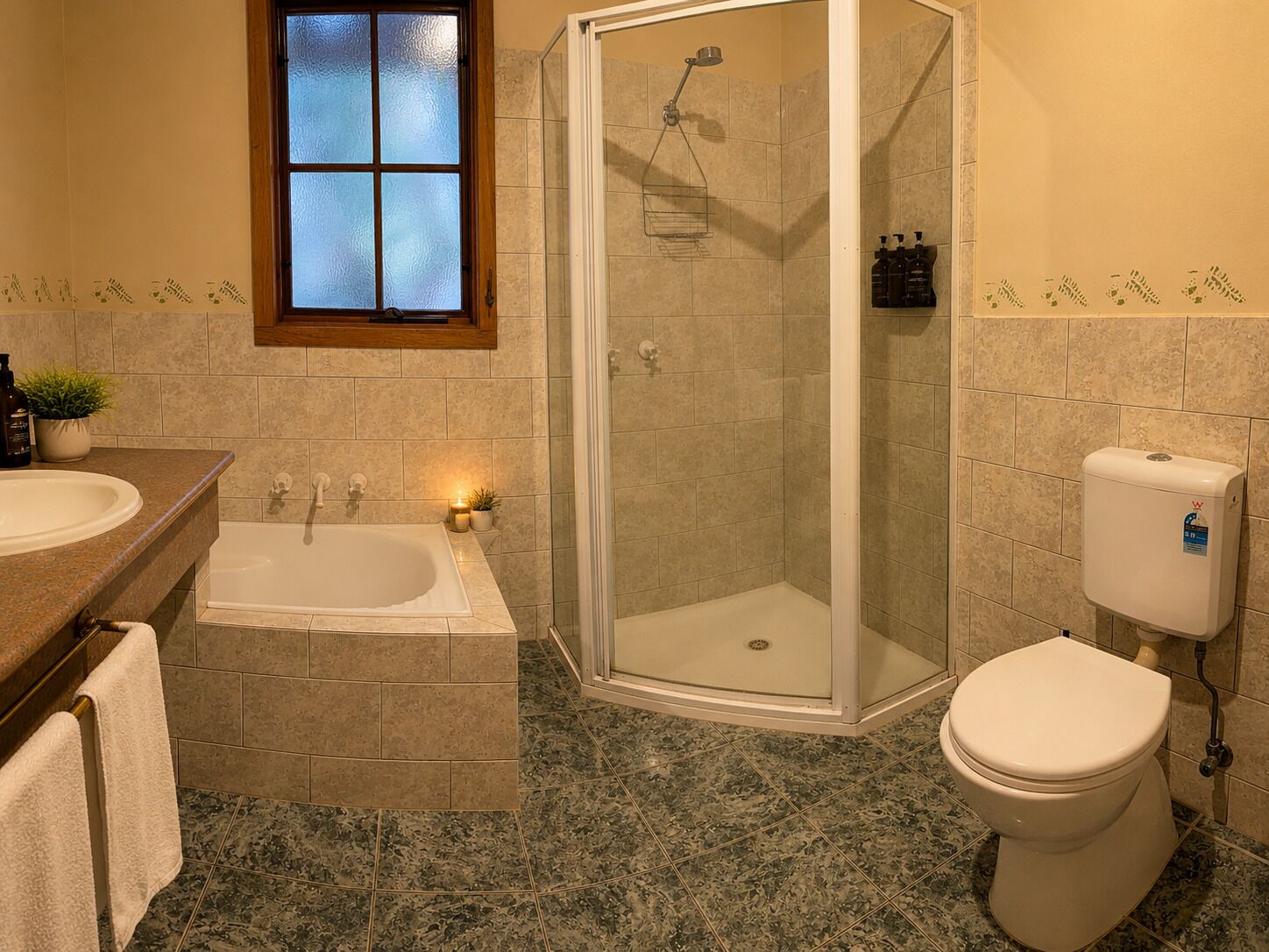 Un baño con bañera, ducha de vidrio y retrete.