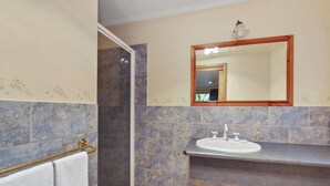 Un bany amb dutxa, un lavabo i un mirall.