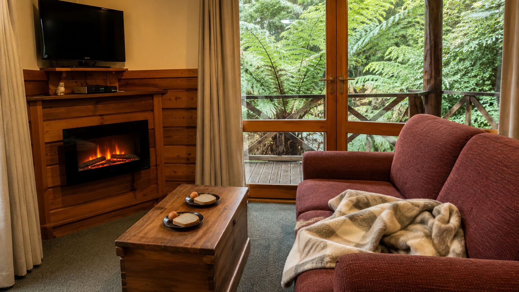 Una sala de estar acogedora con chimenea, televisor y un sofá con una manta.