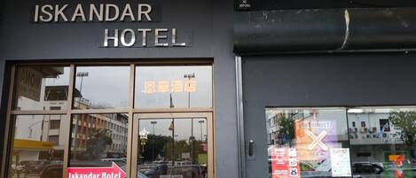 Exterior del hotel Iskandar con un cartel que muestra el nombre del hotel.