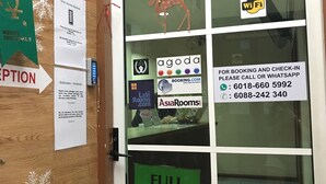 A hotel reception area with a 'FULL HOUSE' sign, a 'WiFi' sign, and a 'Merry Christmas' decoration. - Iskandar Sinsuran Guesthouse (Kota Kinabalu)