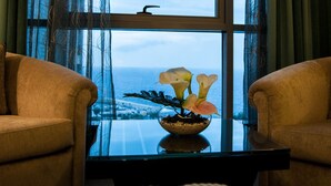 A room with two sofas facing a window with a view of the sea. - Elite Hotel & Spa (Beirut)