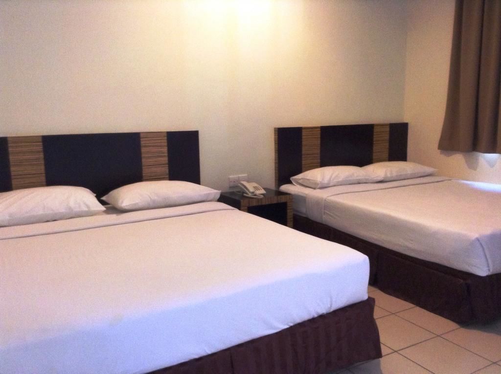 Two single beds with wooden headboards, white bedding, and a nightstand with a telephone.