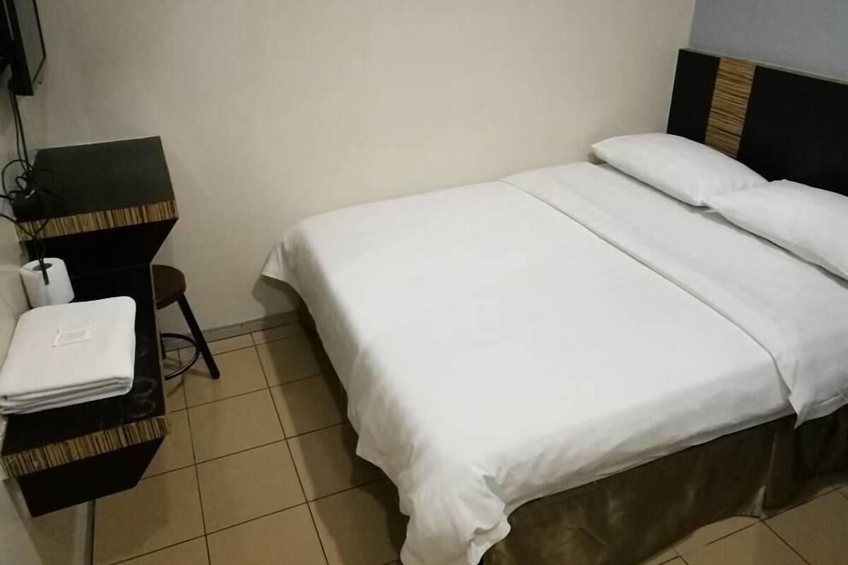 Ein Hotelzimmer mit einem Bett, einem Schreibtisch und einem Stuhl.