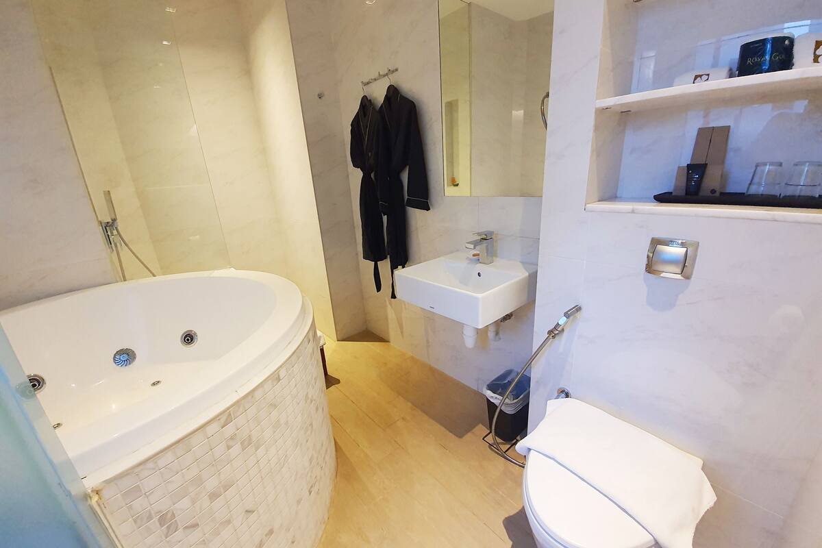 A modern bathroom with a freestanding bathtub, a sink, and a toilet.