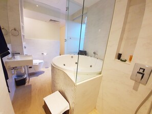 Un baño moderno con una bañera grande, un lavabo independiente y una zona de ducha con mampara de vidrio.
