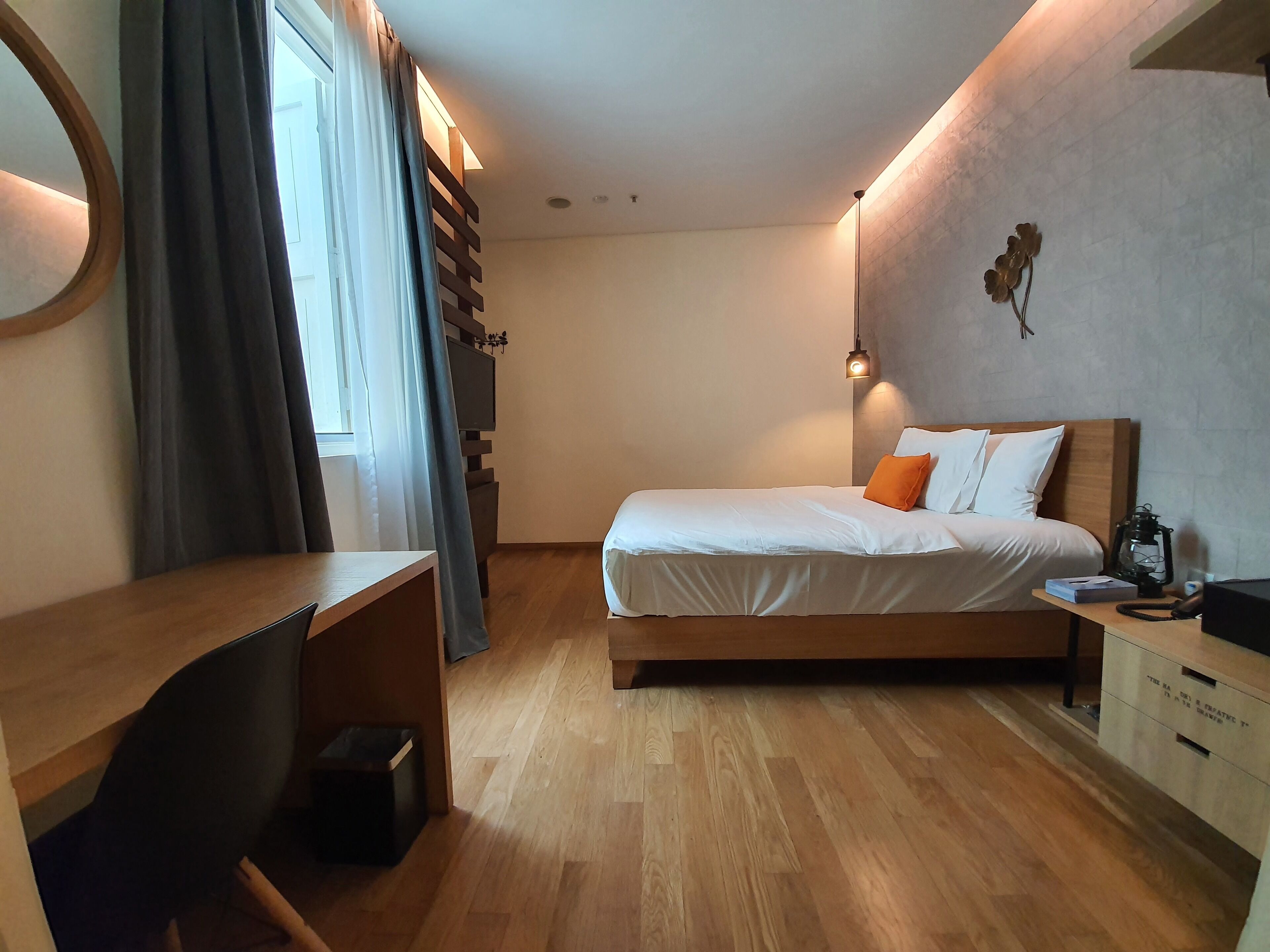 Un dormitorio moderno con una cama de madera, un escritorio y un aparador.