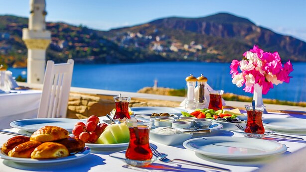 A table set for a meal with a view of the sea and mountains in the background. - Zinbad Hotel (Kas)
