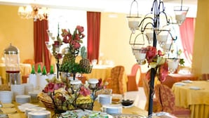 A buffet table with various food items and a decorative centerpiece. - Hotel Federiciano (Valenzano)