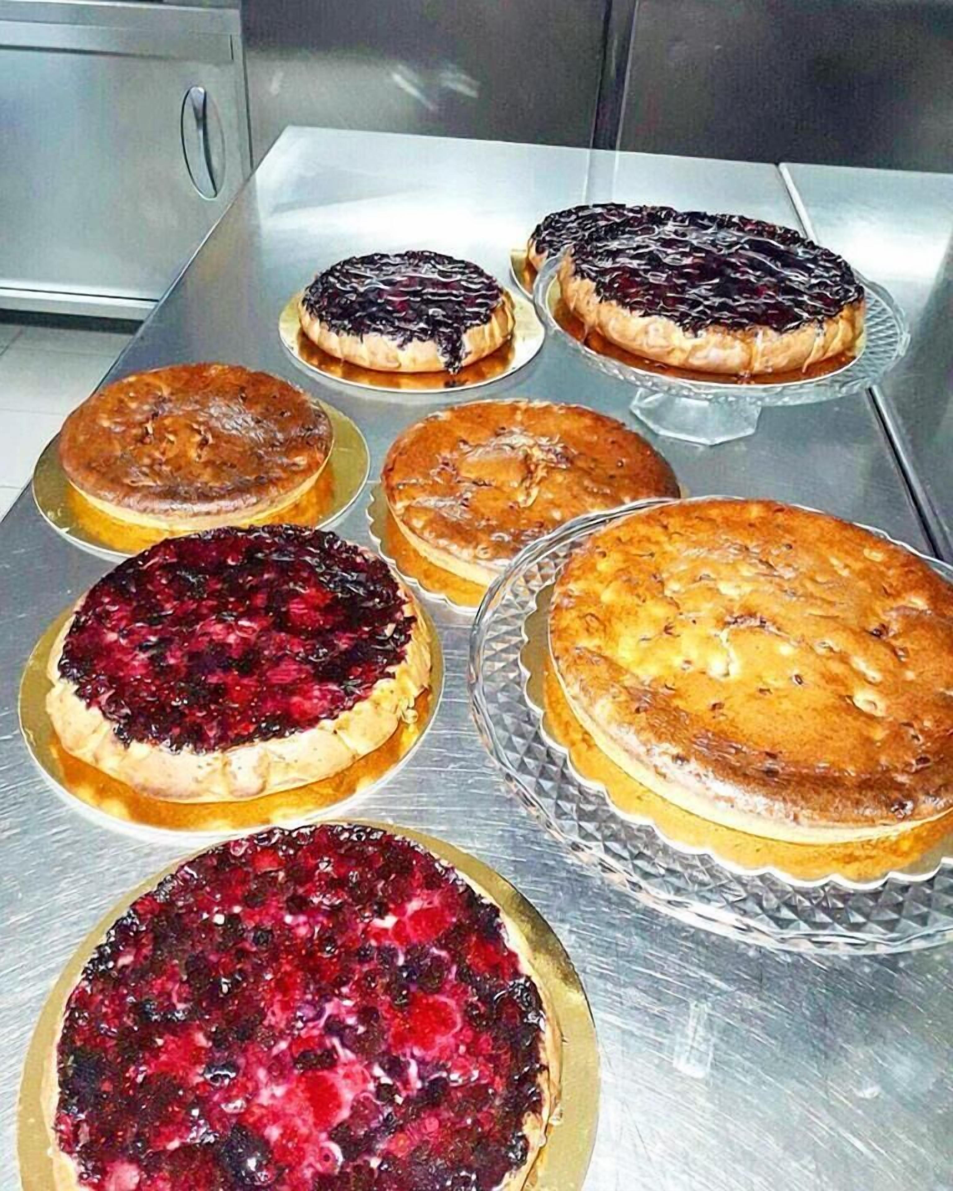 A variety of pies on a stainless steel counter.
