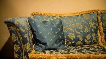 Un sofá azul con estampado floral y detalles dorados.
