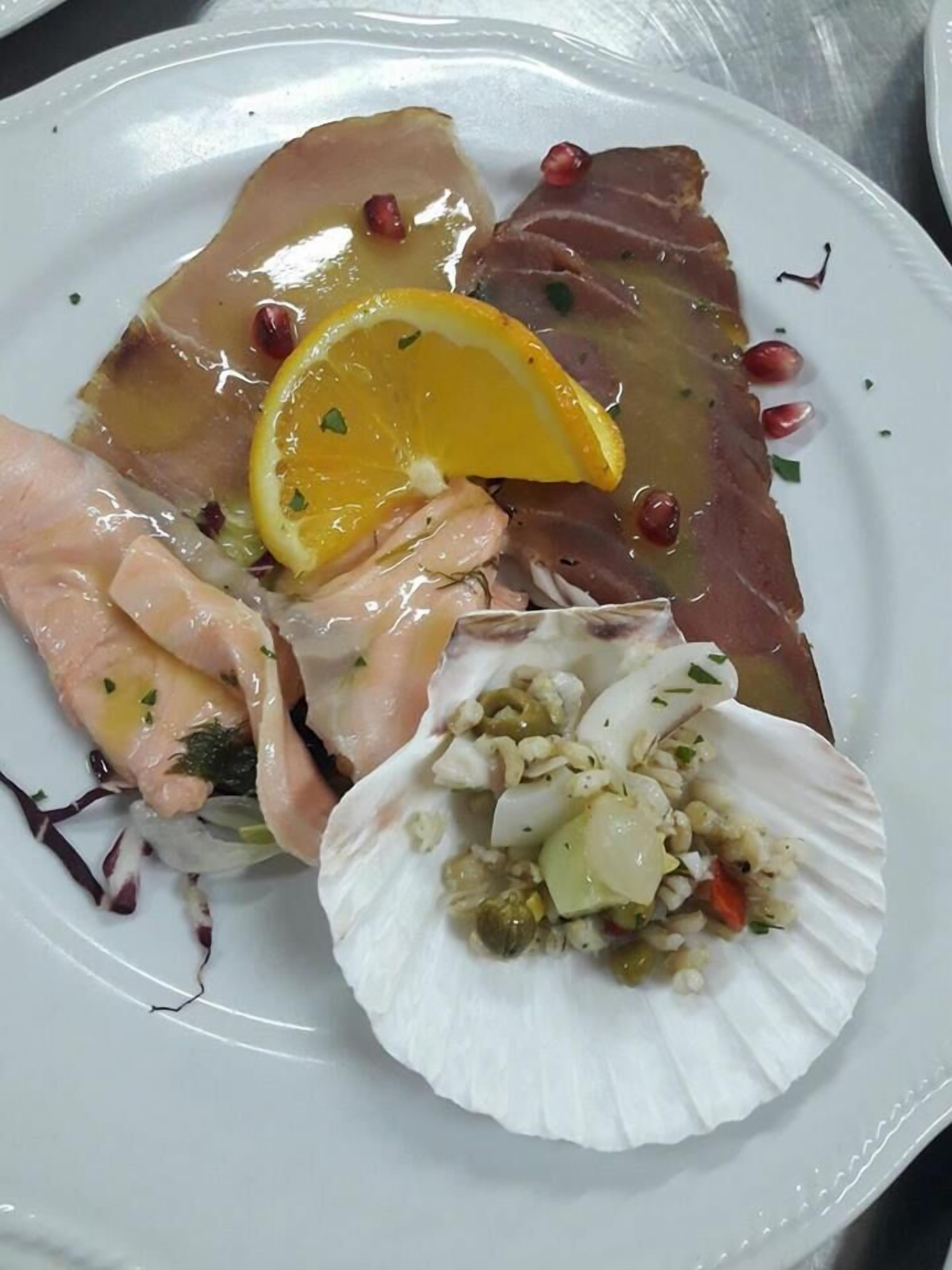 Un plato con diversos mariscos, como pescado, camarones y un vongole.