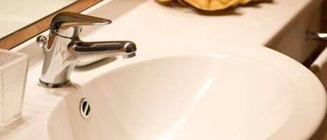 A bathroom sink with a chrome faucet, a mirror above it, and a towel rack to the right.