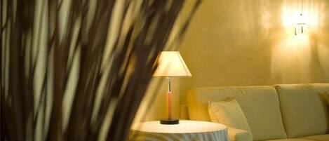 A room with a round table, a lamp, and a sofa.
