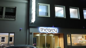 A building with a sign reading "thegrey" and a car parked in front. - The Grey Hotel (Dortmund)